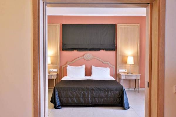 Schlafzimmer im Kresten Royal Euphoria Resort mit einem Doppelbett, zwei Nachttischen und Lampen.
