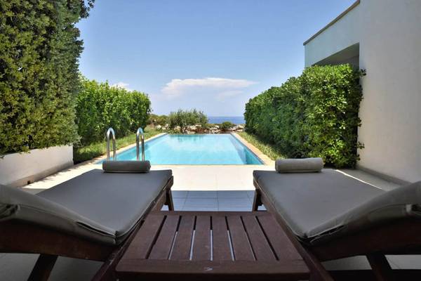 Außenbereich des Kresten Royal Euphoria Resorts mit Swimmingpool und Liegen.