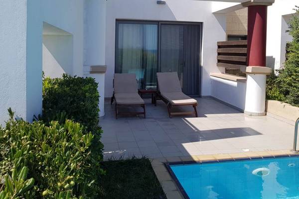 Terrasse des Kresten Royal Euphoria Resorts mit zwei Liegen und Swimmingpool