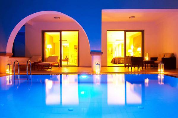Beleuchteter Poolbereich des Kresten Royal Euphoria Resorts bei Nacht mit Loungemöbeln und offenen Türen
