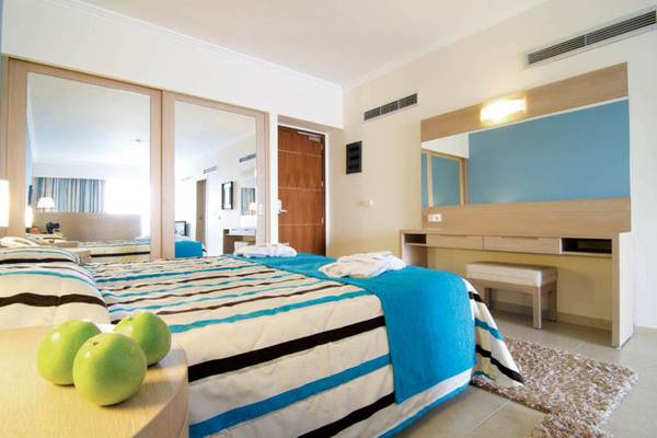 Schlafzimmer im Kresten Royal Euphoria Resort mit zwei Betten, Spiegeln und Nachttischen mit Äpfeln.