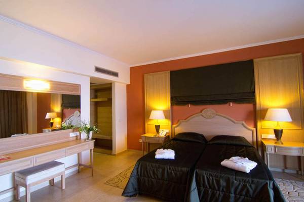Doppelzimmer im Kresten Royal Euphoria Resort mit zwei Betten, Nachttischen, Lampen und einem großen Spiegel.