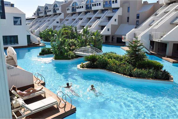 Außenpool des Susesi Luxury Resorts mit Gästen, die schwimmen und entspannen.