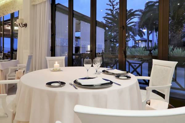 Restaurantbereich des Iberostar Selection Anthelia Hotels mit weißem Tisch und Stühlen.