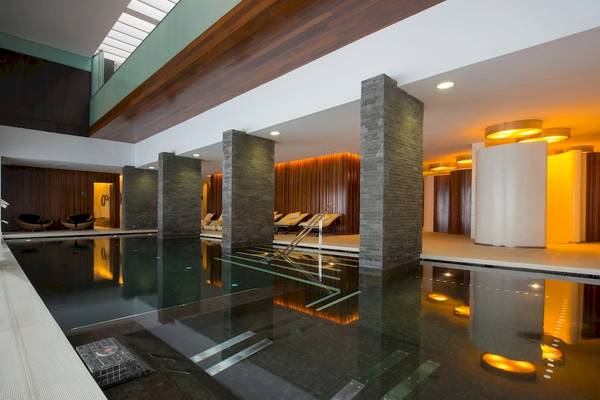 Poolbereich im Iberostar Selection Anthelia Hotel mit Loungeliegen und Holzelementen.