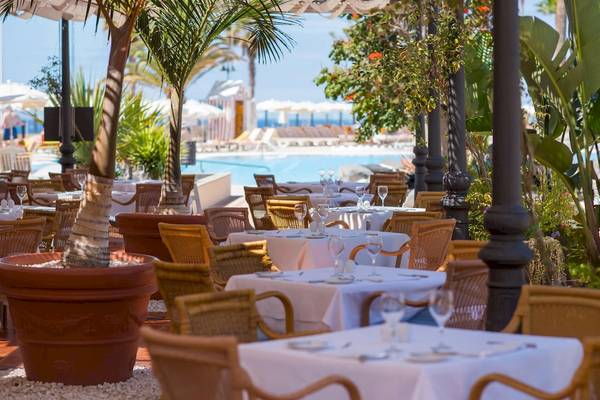 Außenrestaurant am Pool des Iberostar Selection Anthelia Hotels mit gedeckten Tischen und Sonnenschirmen