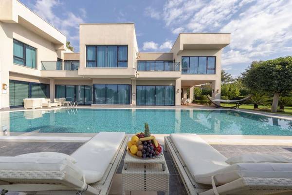 Außenbereich des Susesi Luxury Resorts mit großem Pool und weißen Lounge-Liegestühlen.