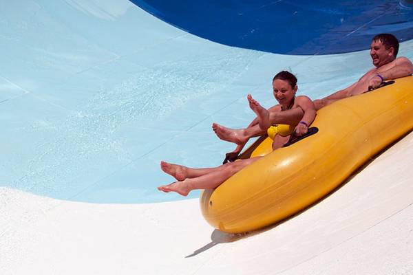 Zwei Personen auf einer gelben Wasserrutsche im Jaz Makadi Oasis Resort & Club.