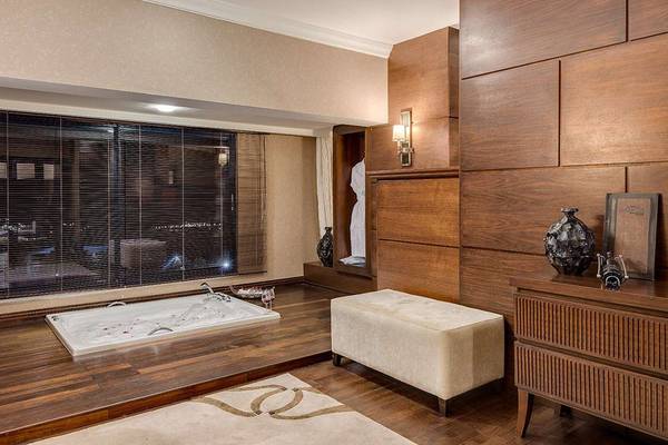 Badezimmer im Susesi Luxury Resort mit Jacuzzi, Holzboden und modernen Möbeln.