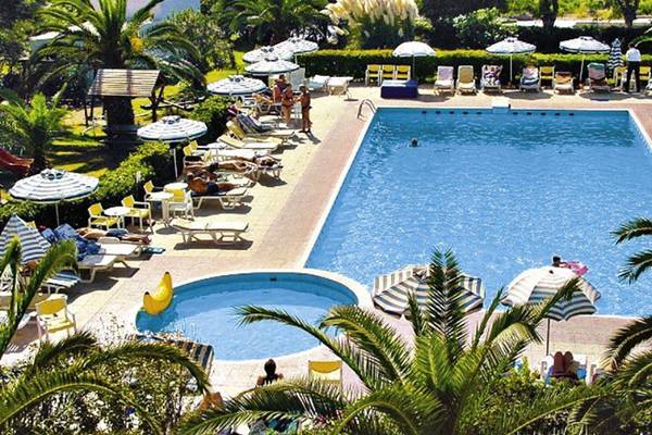 Pyli Bay Hotel Außenpool mit Liegestühlen und Sonnenschirmen.