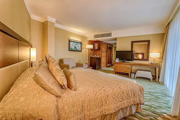 Hotelzimmer im Susesi Luxury Resort mit Doppelbett, Fernseher und Dekor.