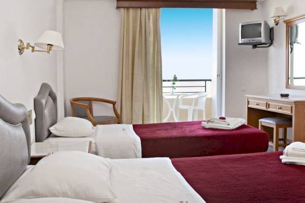 Doppelzimmer im Dedalos Beach Hotel mit zwei Betten, Balkon und Meerblick.