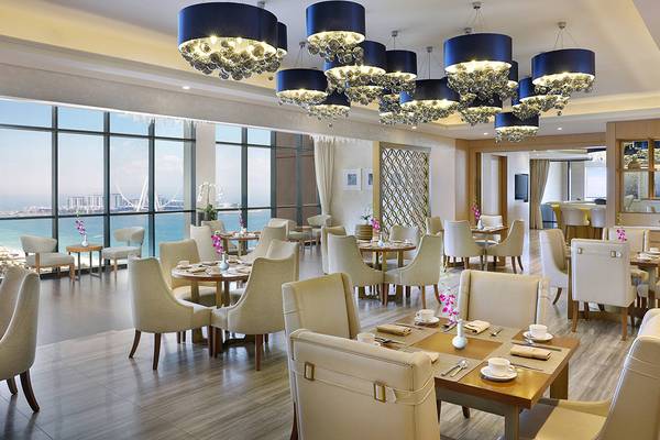 Innenansicht des Restaurants im Habtoor Grand Resort & Spa mit Blick auf das Meer.