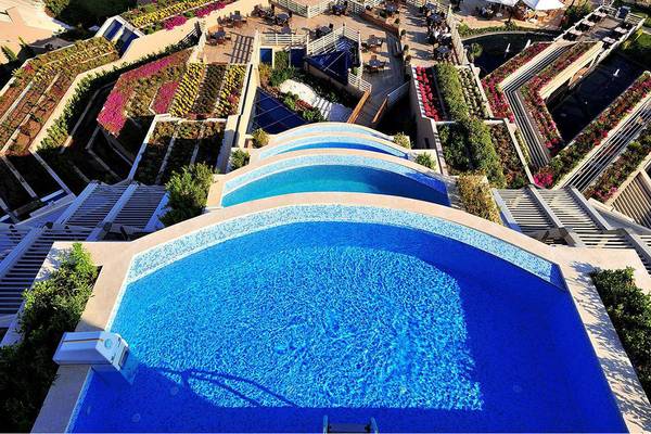 Luftaufnahme des Susesi Luxury Resorts mit mehreren Swimmingpools und grünen Gärten.