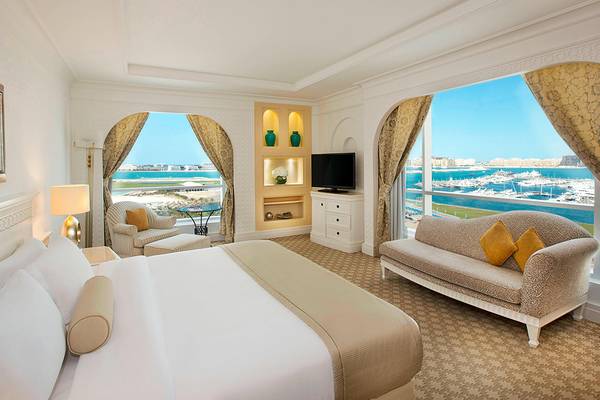 Suite im Habtoor Grand Resort & Spa mit Meerblick, Bett, Sofa und Fernseher.