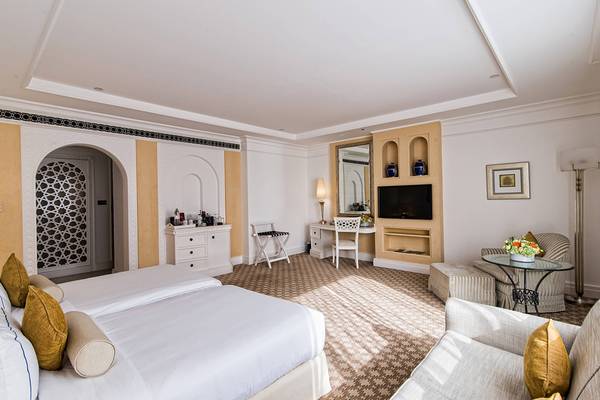 Schlafzimmer im Habtoor Grand Resort & Spa mit zwei Betten, Schreibtisch, Fernseher und Dekor.
