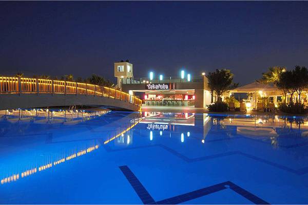 Der Swimmingpool des Susesi Luxury Resort bei Nacht mit einer Brücke und einer Bar