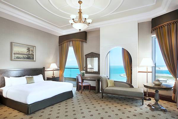 Suite Zimmer im Habtoor Grand Resort & Spa mit Meerblick, Bett, Schreibtisch und Sofa.