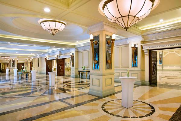 Eingangsbereich des Habtoor Grand Resort & Spa Hotels mit Marmorboden und Kronleuchtern.