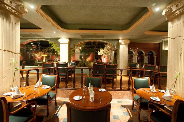 Innenansicht des Restaurants im Grand Resort Hurghada mit runden Tischen und Stühlen.