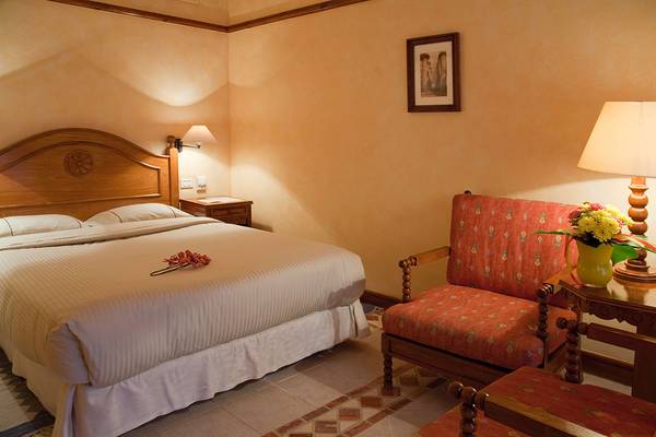 Hotelzimmer im Grand Resort Hurghada mit Bett, Nachttisch und Sessel.