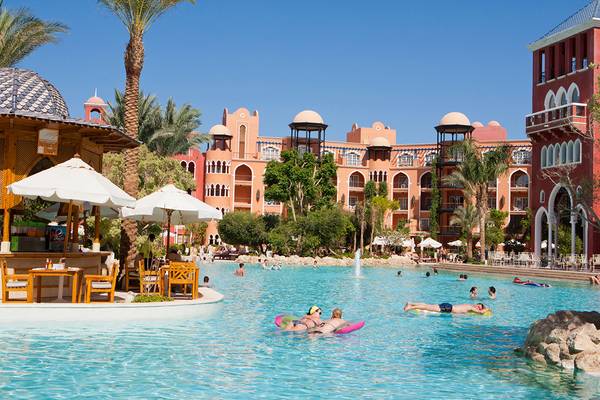 Gäste entspannen im Pool des Grand Resort Hurghada mit Blick auf das Hotel