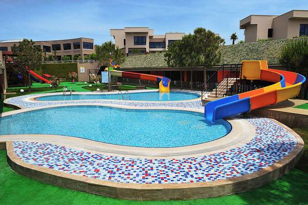 Außenbereich des Susesi Luxury Resort mit einem großen Kinderpool und einer bunten Wasserrutsche.