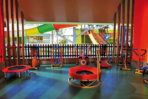 Kinderspielplatz im Susesi Luxury Resort mit verschiedenen Spielgeräten und einer bunten Rutsche im Hintergrund.