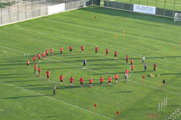 Spieler des Susesi Luxury Resort stehen im Kreis auf einem Fußballfeld.