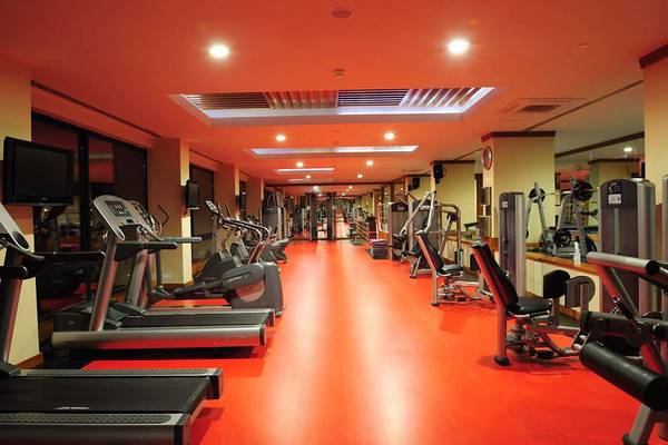 Fitnesscenter im Susesi Luxury Resort mit roten Böden und vielen Trainingsgeräten.
