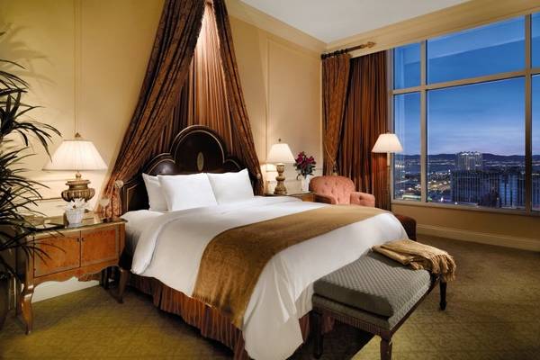 Luxuriöses Schlafzimmer im Venetian Resort Hotel & Casino mit Bett, Nachttischen und Ausblick auf die Stadt.