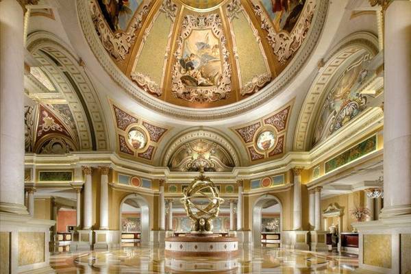 Innenansicht des Venetian Resort Hotel & Casino mit goldenen Deckengemälden und einer zentralen Skulptur.
