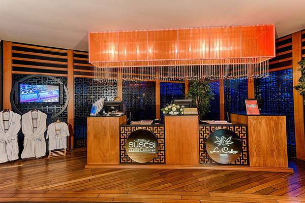 Empfangsbereich des Susesi Luxury Resort mit Rezeptionstresen, Roben und Fernseher