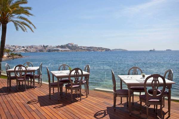 Terrasse mit Tischen und Meerblick im Torre del Mar Hotel