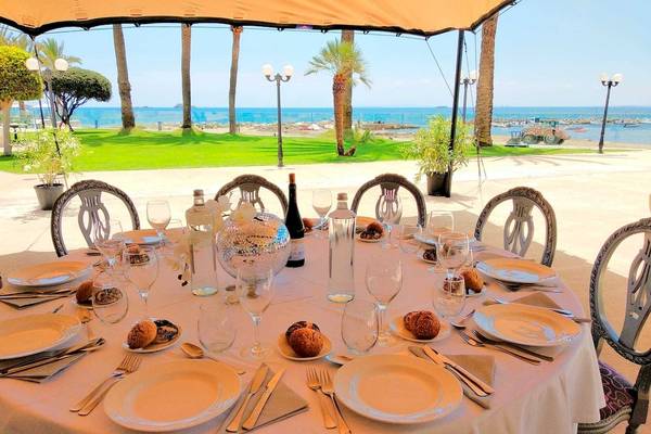 Ein Tisch im Hotel Torre del Mar, gedeckt mit Tellern, Gläsern und Besteck, mit Blick auf das Meer.