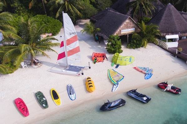 Luftaufnahme des Adaaran Select Hudhuran Fushi Resorts mit Wassersportgeräten und Bungalows am Strand
