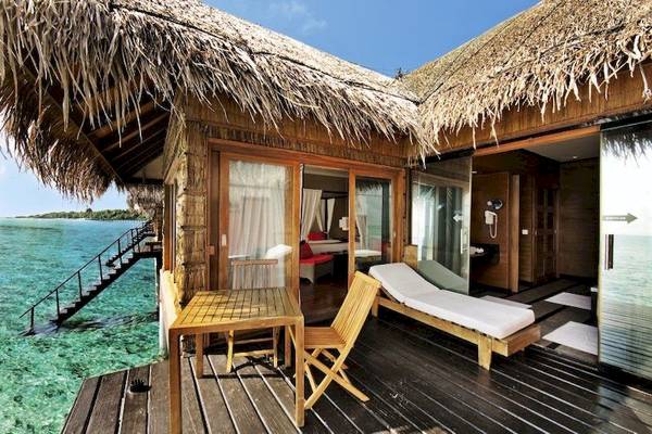 Außenterrasse des Adaaran Select Hudhuran Fushi Hotels mit Blick auf das Meer.