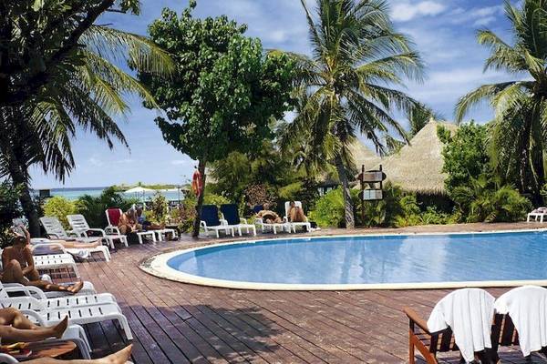 Außenpool im Adaaran Select Hudhuran Fushi Hotel mit Sonnenliegen und Palmen.