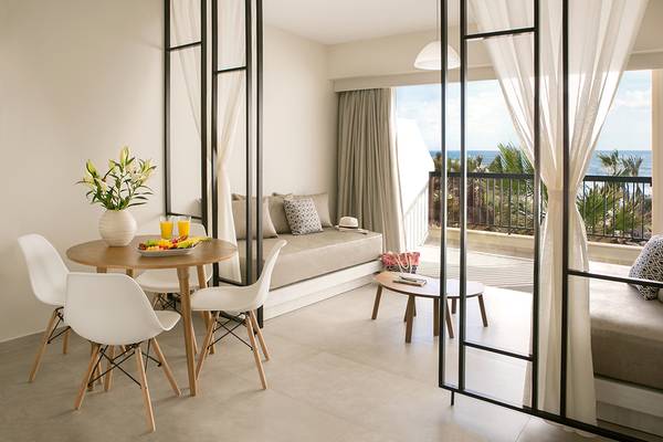 Balkon des Louis Paphos Breeze Hotels mit Sitzecke und Tisch im Innenraum