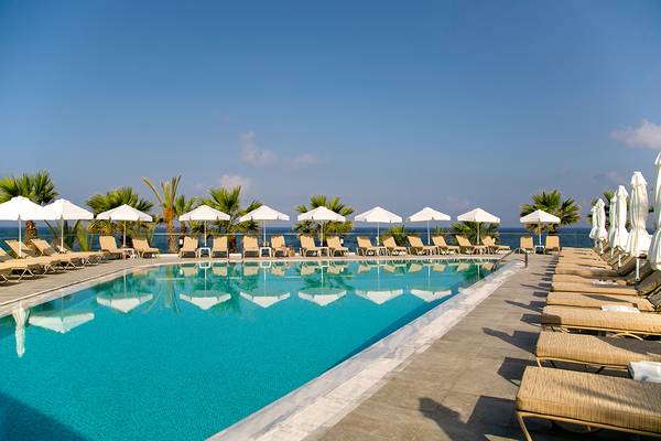 Der Außenpool des Louis Paphos Breeze Hotels mit Sonnenliegen und Sonnenschirmen