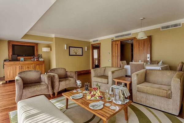 Wohnbereich der Suite im Susesi Luxury Resort mit Möbeln und Früchten auf dem Tisch.