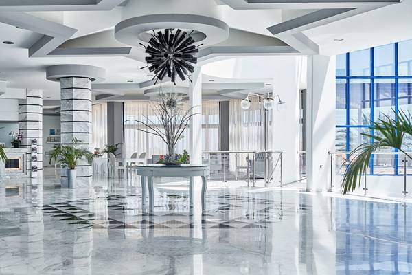 Lobby des Rodos Princess Beach Hotels mit Marmorboden, modernen Möbeln und Pflanzen.