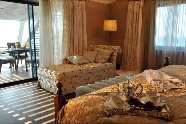 Schlafzimmer im Susesi Luxury Resort mit Bett, Tagesbett, Tisch und Terrassenblick