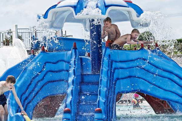 Drei Kinder spielen auf einer blauen Wasserrutsche im Rodos Princess Beach Hotel.