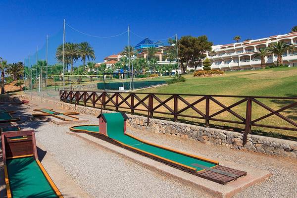 Minigolfplatz im Freien im Rodos Princess Beach Hotel mit Palmen und Gebäude im Hintergrund.