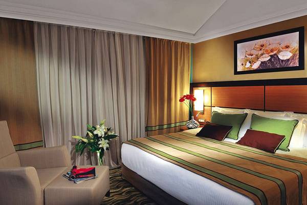 Schlafzimmer im Susesi Luxury Resort mit Bett, Kissen, Dekor und Kunst an der Wand.