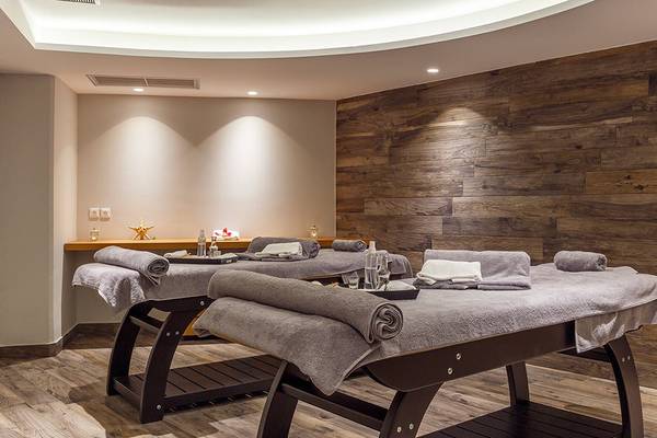 Massagebereich im Rodos Princess Beach Hotel mit zwei Massagetischen und Holzwänden.