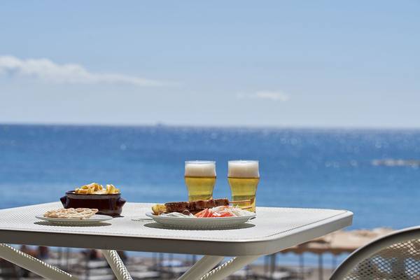 Tisch am Strand mit Getränken und Essen vor einer schönen Meereskulisse