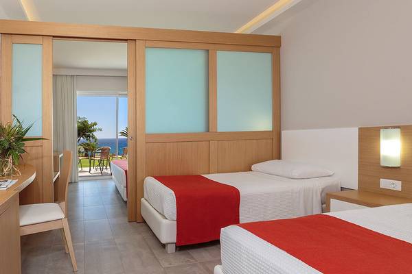 Innenansicht eines Zimmers im Rodos Princess Beach Hotel mit zwei Betten, Meerblick und Balkon.