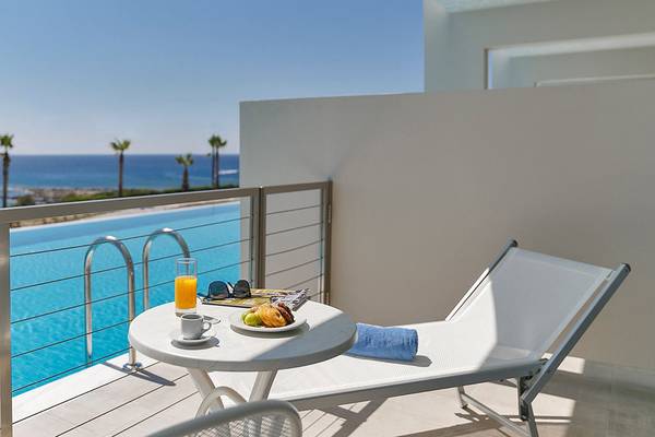 Balkon des Rodos Princess Beach Hotels mit Blick auf das Meer, einem Swimmingpool und Sonnenliegen.